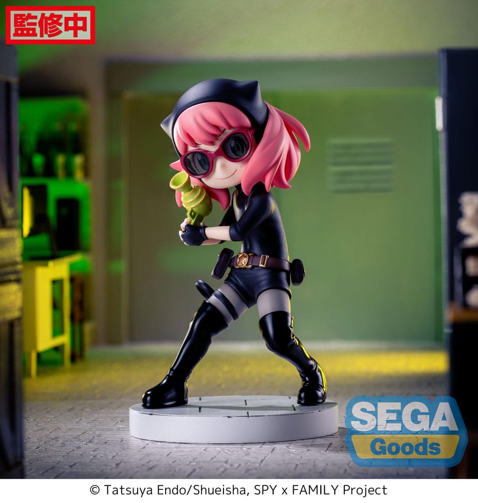 Figurine d’Anya Forger en tenue d’espionne noire avec lunettes, bottes et ceinture, tenant un pistolet-jouet vert, debout sur un socle pavé. Inspirée de la série Spy x Family.