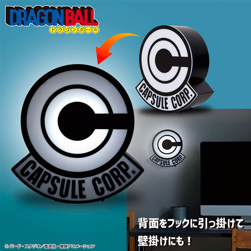 Lampe Dragon Ball représentant le logo Capsule Corp noir et blanc sur socle, avec le logo Dragon Ball en haut de l’image.