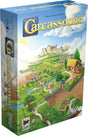 Boîte du jeu Carcassonne avec paysage médiéval, cité fortifiée, routes, champs et tuiles en cours de placement.
