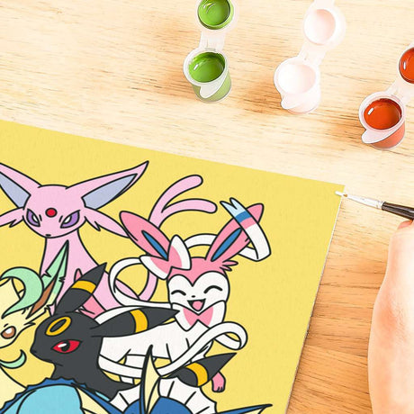 CreArt Ravensburger Pokémon Pikachu & Évoli, peinture par numéros 24 x 30 cm avec Pikachu, Évoli et plusieurs Évolitions sur fond jaune.