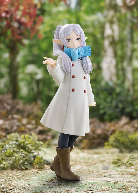 Figurine Pop Up Parade de Frieren en manteau blanc, version Blow Kiss, posée dans un décor forestier.