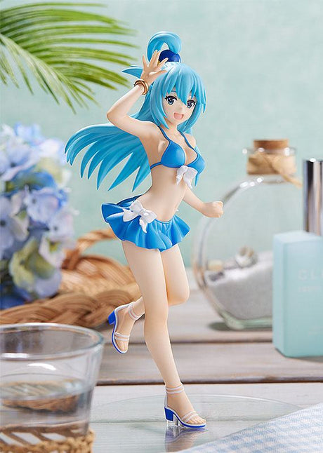 Figurine Pop Up Parade d’Aqua de KonoSuba en maillot de bain bleu, capturant son énergie débordante dans un décor estival raffiné.