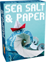 Boîte du jeu Sea Salt & Paper avec vague en origami bleu et blanc et petit bateau en papier rouge sur fond bleu.