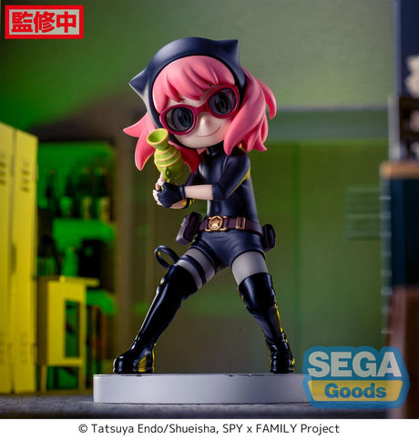 Figurine d’Anya Forger en tenue d’espionne noire avec lunettes, bottes et ceinture, tenant un pistolet-jouet vert, debout sur un socle pavé. Inspirée de la série Spy x Family.