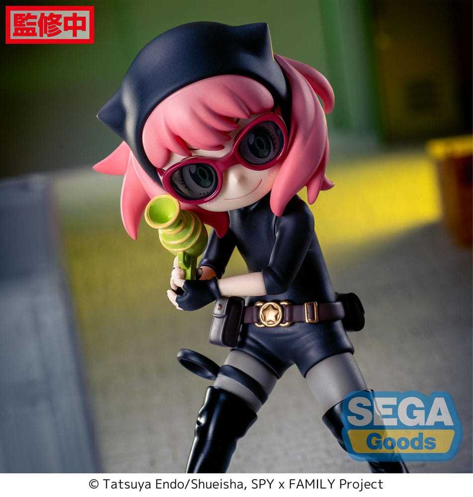 Figurine d’Anya Forger en tenue d’espionne noire avec lunettes, bottes et ceinture, tenant un pistolet-jouet vert, debout sur un socle pavé. Inspirée de la série Spy x Family.