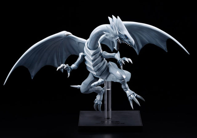 Figurine Yu-Gi-Oh! Oshi Works Dragon Blanc aux Yeux Bleus argenté, ailes déployées sur socle d’exposition noir.