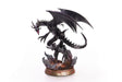 Figurine en PVC de Red-Eyes Black Dragon, le célèbre dragon noir de Yu-Gi-Oh!, dans une pose agressive avec ailes déployées. Le socle est orné de lave en fusion et de roches sombres.