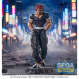 Figurine Baki Luminasta Yujiro Hanma par Sega, représentant Yujiro en tenue noire, mains dans les poches, cheveux rouges et posture menaçante sur un socle urbain.