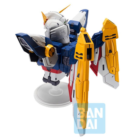 Figurine Bandai Ichibansho Wing Gundam 30th Anniversary sur socle, avec armure blanche, bleue, rouge et jaune et ailes mécaniques.
