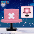 Lampe décorative One Piece Hat Room Light Chopper en forme de chapeau rose avec croix blanche sur socle noir.
